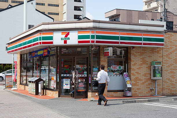7-Eleven Convenience Store "Nagoya, Japan - March 26, 2012 : People go to the 7-Eleven Convenience Store. This store is located in 2-chome, Izumi, Nagoya, Aichi Prefecture, Japan. 7-Eleven is a international chain of convenience stores." tokai region photos stock pictures, royalty-free photos & images