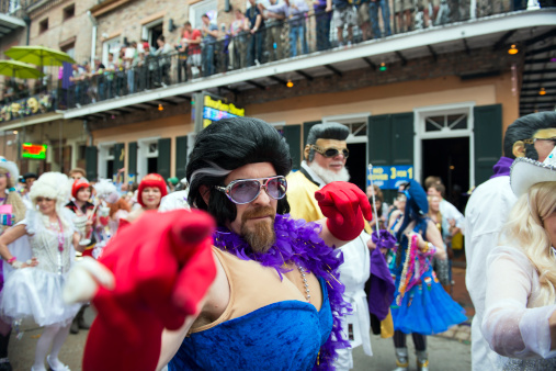 New Orleans, Louisiana, USA - February 8, 2013: A man who sort of looks like Elvis is among the costumed people in a small parade down Bourbon Street during Mardi Gras.