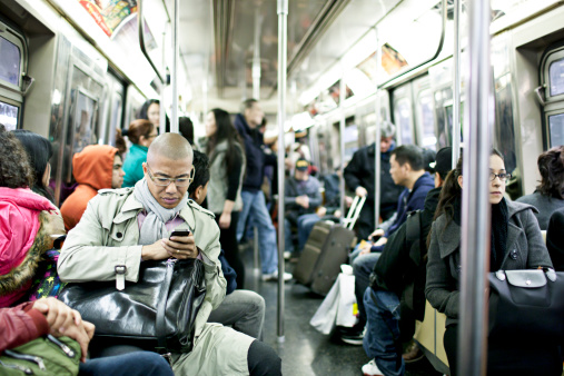 New York, USA - March 15, 2012: People traveling  in a busy subway train in New York city.