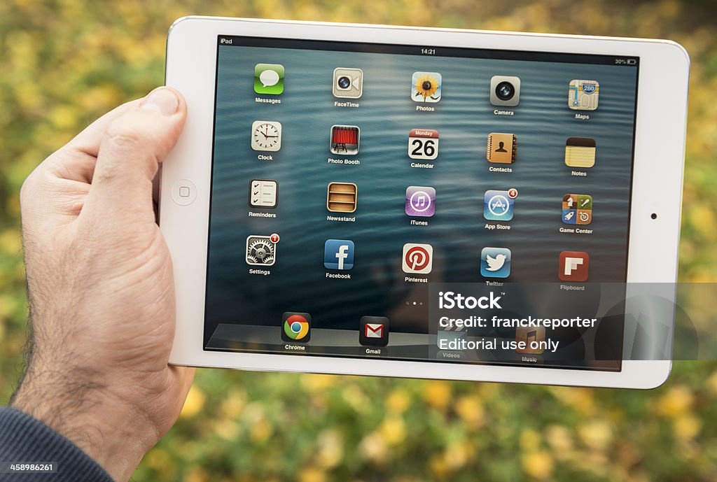 Mano humana sosteniendo el nuevo Ipad Mini al aire libre - Foto de stock de Agarrar libre de derechos