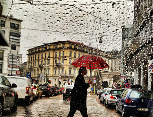 uomo con ombrello sotto la pioggia strada di attraversamento di milano, italia - mobilestock foto e immagini stock