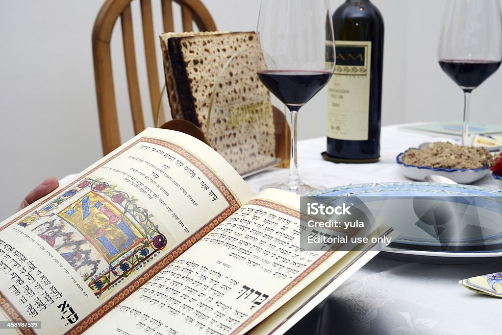 Jewish passover Wine and matzoh "Bat Yam, Israel- March, 25, 2013: Jewish passover - seder, Wine glass, wine bottle ,hagadah  and matzoh" Passover Stock Photo