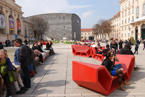 Vienna, Austria - April 13, 2012: People resting in main courtyard of MuseumsQuartier in Vienna. MuseumsQuartier is one of the largest cultural centres in the world. It houses over 20 different cultural instituions. There are several museums such as Leopold museum, MUMOK, quartier21.