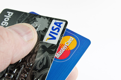 Bruce, Canada - May 15, 2012: A Visa and Mastercard held against a white background. MasterCard is an American financial services corporation for credit and debit cards with the main offices in New York. Visa is the main competitor to Mastercard which bagan use in England and is now used worldwide.