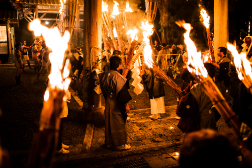 Kyoto, Japan - October 22, 2012: People with torches at the Kurama Himatsuri in the streets of the northern suburb of Kyoto in Kurama. Every 22 of october from 6pm to midnight people carry small a huge  torches weighting more than 80 kilograms through the main street of Kurama. This is an ancient rite in which the spirits of hell are guided by the light of pine torches through the human realms. It has also a relation with the emperor that started to send torch bearers from the palace to the village in the year 794.  The older boys and men are dressed in traditional loincloths.