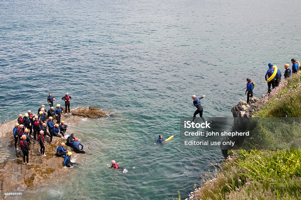 Group of people Tombstoning in Newquay Newquay, United Kingdom - June 8, 2010: An organised group of people tombstoning from cliffs near headland point, Newquay, Cornwall. Activity Stock Photo
