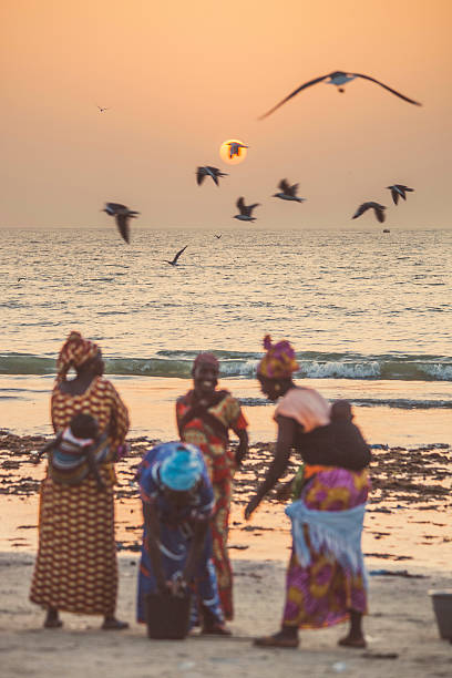 Lomé, Togo - June 30, 2019: Young women enjoy the beach of Lomé at the late afternoon.
