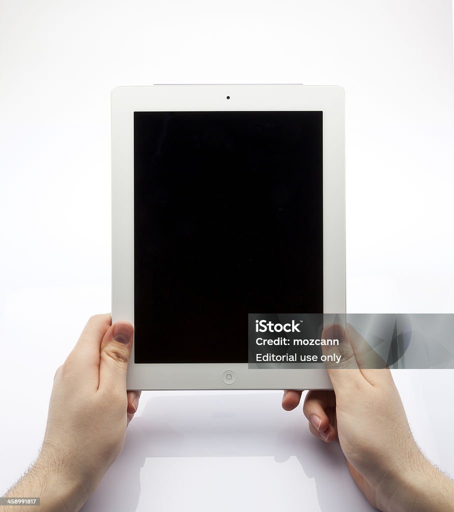 New ipad on hands "Istanbul, Turkey - May 12, 2012: New ipad on male hands. To operate the new ipad, people must press the button that just middle of the body frame." Big Tech Stock Photo