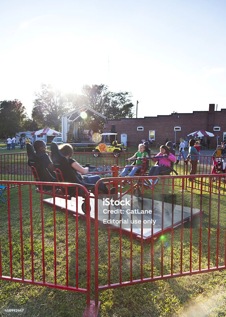 Children Enjoying Ride "Suffolk, Virginia, USA - October 22, 2011: A vertical shot of children riding a hand-powered fairground ride at a free community street event in Driver, Suffolk, VA." African Ethnicity Stock Photo