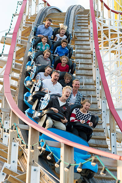 Riders scream on a ride at Stockholm's Grona Lund "Stockholm, Sweden - August 17, 2012: Riders scream as the rollercoaster called Twister swooshes past.This ride reaches a speed of 61 km/h and the riders are suscepted to forces up to 3G.The highest point is 15 m above the sea level.The Grona Lund amusement park is situated near the city center of Stockholm." djurgarden photos stock pictures, royalty-free photos & images