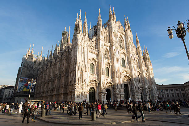 Milan Cathedral "Milan, Italy - February 08, 2013: The Piazza del Duomo square full of people and tourists in front of Duomo Cathedral. The famous gothic cathedral Duomo di Milano is one of the largest in the world." candoglia marble stock pictures, royalty-free photos & images