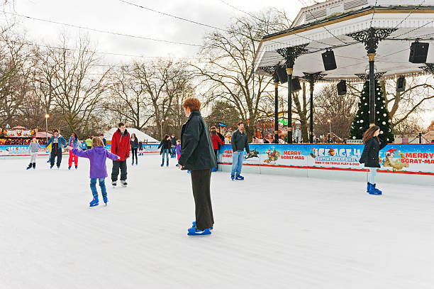 冬のワンダーランドの屋外アイスリンク - ice skating young couple daughter mother ストックフォトと�画像