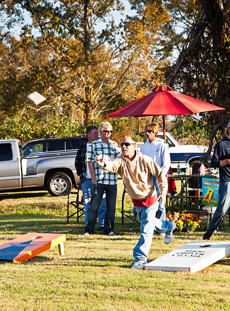 mężczyźni gra cornhole - cornhole leisure games outdoors color image zdjęcia i obrazy z banku zdjęć