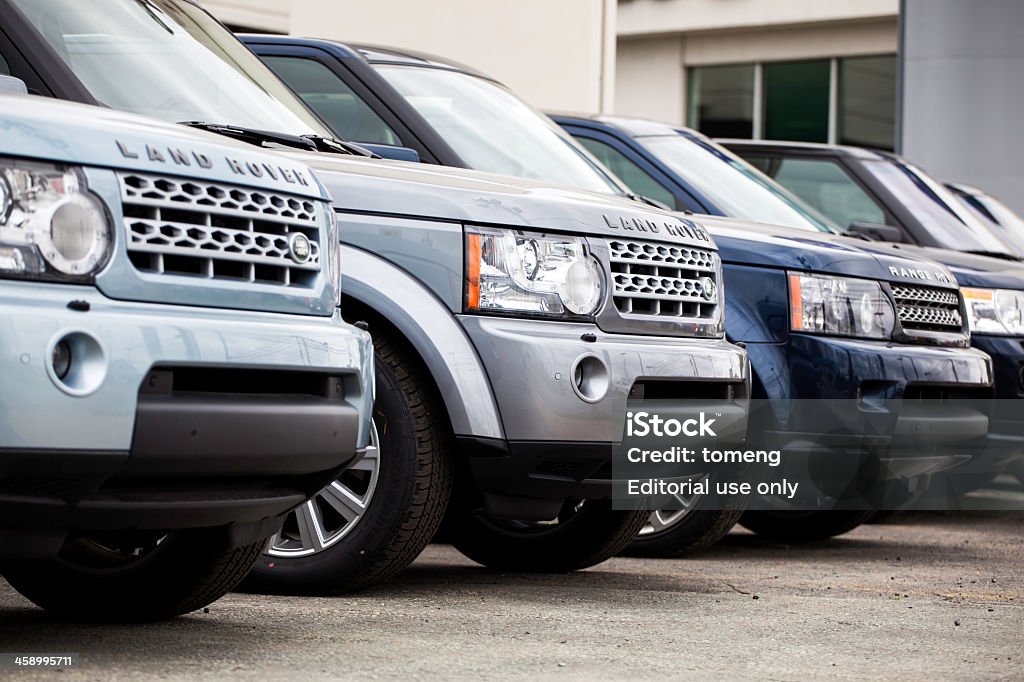 New Land Rover Vehicles in a Row Halifax, Nova Scotia, Canada - June 3, 2012: New Land Rover vehicles at a car dealership.  Various colors of Land Rover models continue in the row of vehicles.  Dealership building visible in background.  Land Rover manufacturers a range of four-wheel drive vehicles including the pictured Land Rover and Range Rover, as well as the Defender, and Evoque to name a few. Land Rover Stock Photo