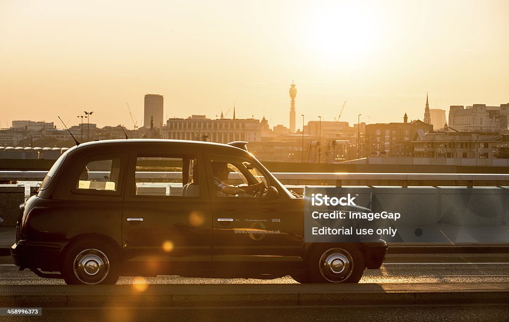Sunset Cab Ride "London, England - July 26, 2012: London black taxi crossing over London Bridge with a passenger looking out over the west of the city" Black Cab Stock Photo
