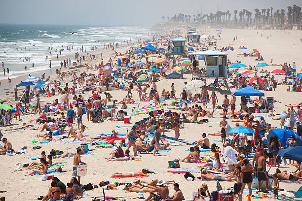 huntington beach em um movimentado dia de fim de semana de verão. - crowd surfing - fotografias e filmes do acervo