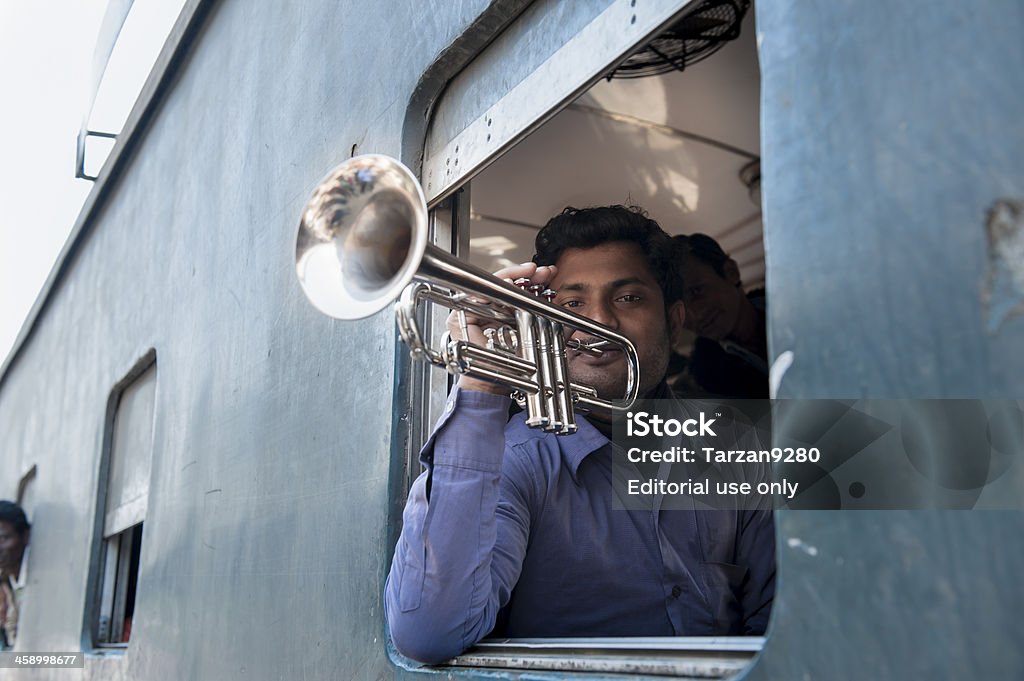 Homem tocando trompete na janela de compartimento, Bangladesh - Foto de stock de Brincar royalty-free