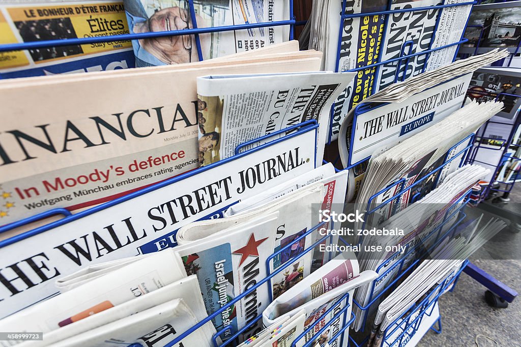 Economy Newspapers on a Newsstand "London, United Kingdom- July 11, 2011: Financial Newspapers on a Newsstand including the financial times and the Wall Street Journal. The Financial Times (FT) is a morning daily newspaper published in London and printed in 24 cities around the world." News Stand Stock Photo