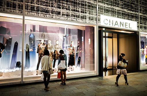 Tokyo, Japan - October 13, 2012: Women walking in front of Chanel luxury store in Ginza Tokyo Japan. This luxury brand founded in 1909 by Coco Chanel specializes in high couture to parfums and other luxury goods.With over 300 shops worldwide this shop in Ginza is the flagship store in Japan.