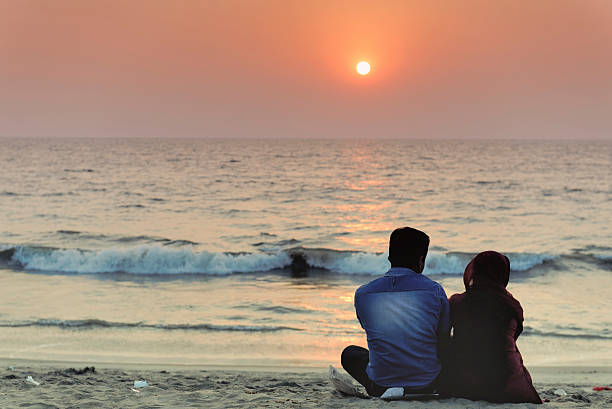 paar genießen einen romantischen sonnenuntergang am strand - image title stock-fotos und bilder