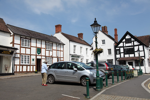 Church Stretton,UK - May 21, 2012: Church Stretton town square, with parked cars and an old person walking to his car.