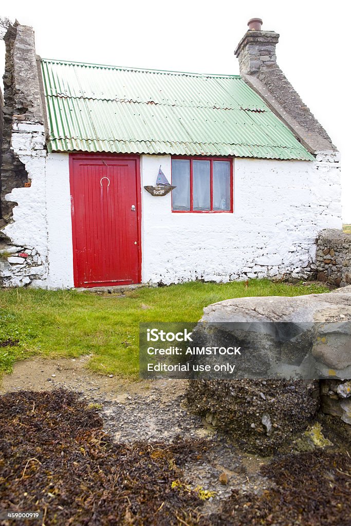 Ireland - Editorial Fenit, County Kerry, Ireland - September 22, 2011: Red door cottage on the strand in the village of Fenit, not far from Tralee, which is the economic and administrative center of county Kerry, South West of Ireland. Color Image Stock Photo