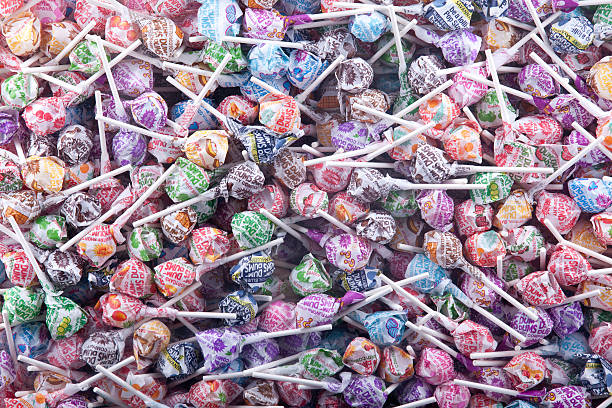 Dum Dumb Lolly Pops "Philadelphia, United States - August 4, 2012:This is a box of thousands of Dum Dum Pops, a type of lolly pop candy. They are all still wrapped and all the different flavors are present in the photo." dum dum LOLIPOPS stock pictures, royalty-free photos & images