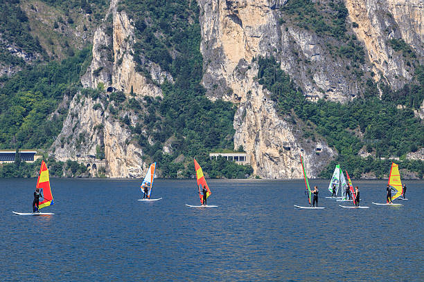 Torbole sul Garda, Italy - June 10, 2009: A group of young people during a windsurfing lesson. Thanks to the constant wind, the northern tip of the Lake Garda is the ideal place for windsurfing, kite surfing and sailing and is is recognized as a center of international importance. Torbole sul Garda particularly is visited every year by thousands of enthusiasts.