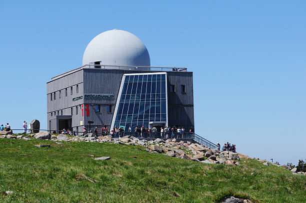 Peak of Brocken Mountain at Harz National Park (Germany) "Brocken, Germany - May 26, 2012: Peak of Brocken Mountain at Harz National Park (Saxony-anhalt, Germany) with its Brockenhaus (Information house of Harz National Park). In front a group of people waiting outside the Brockenhaus." sendemast stock pictures, royalty-free photos & images