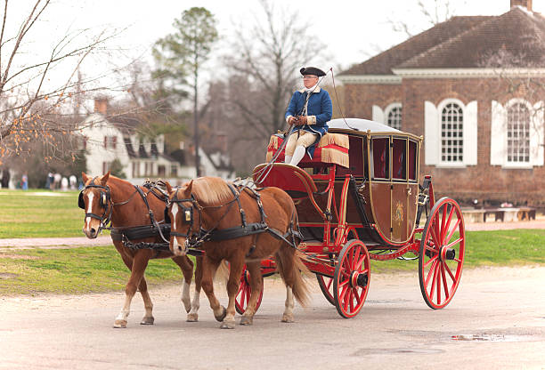 carriage ride in williamsburg virginia "Williamsburg, Virginia, USA - March 3, 2012: Winter scene, a carriage ride through the Historic Area of Williamsburg, Virginia. The riders dress in Colonial attire. There are people with traditional costume around the old town and they use to interact with visitors as well to reenact vignettes and historic moments of this period of the United State history" colonial style stock pictures, royalty-free photos & images