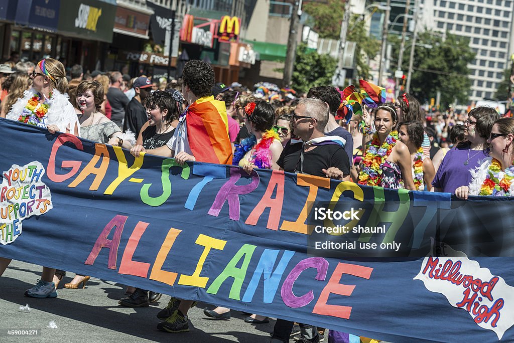 Gay-Straight Alliance "Halifax, Canada - July 28, 2012: A group of students with the Gay-Straight Alliance at Millwood High School carry a banner and march down Spring Garden Road with a massive audience of onlookers during the 25th annual Halifax Pride Parade." Gay Person Stock Photo