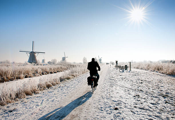 cyclist 니어 풍차 at 킨더다이크 in 극지 기후 - tranquil scene windmill netherlands dutch culture 뉴스 사진 이미지