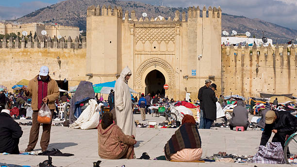 Marrakech, Morocco - June 5, 2025: People shopping for sweets and pastries from a street vendor in Marrakech, Morocco, showcasing local daily life and traditional cuisine in a bustling market setting
