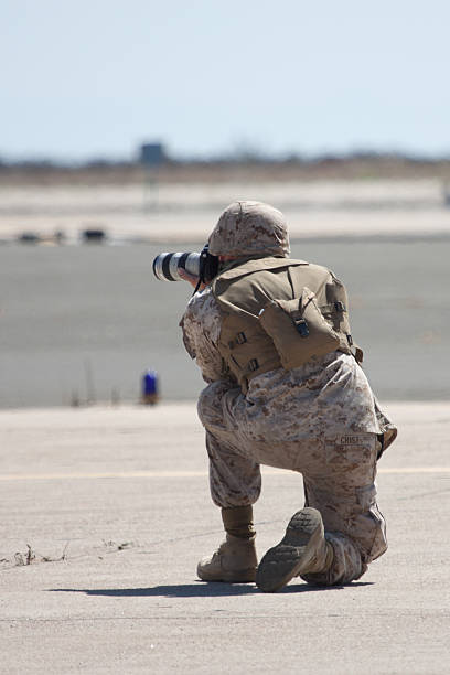 Conflict Photographer "San Diego, United States- October 1, 2011:  This image shows a soldier in camouflage gear pointing a Canon camera away from the audience during a demonstration at the Marine Corps Air Station Miramar Airshow. 2011 marks 100 years of naval aviation." miramar air show stock pictures, royalty-free photos & images