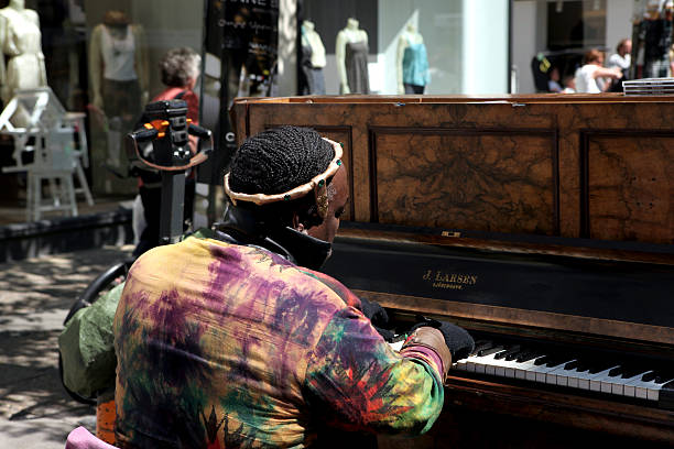 Copenhagen, Denmark - June 11, 2011: A man playing piano outdoors on a busy pedestrian and shopping street in the center of Copenhagen, Denmark. Name of the pianist is Yul Anderson.  He is promoting his future concert in october in Copenhagen, Denmark .