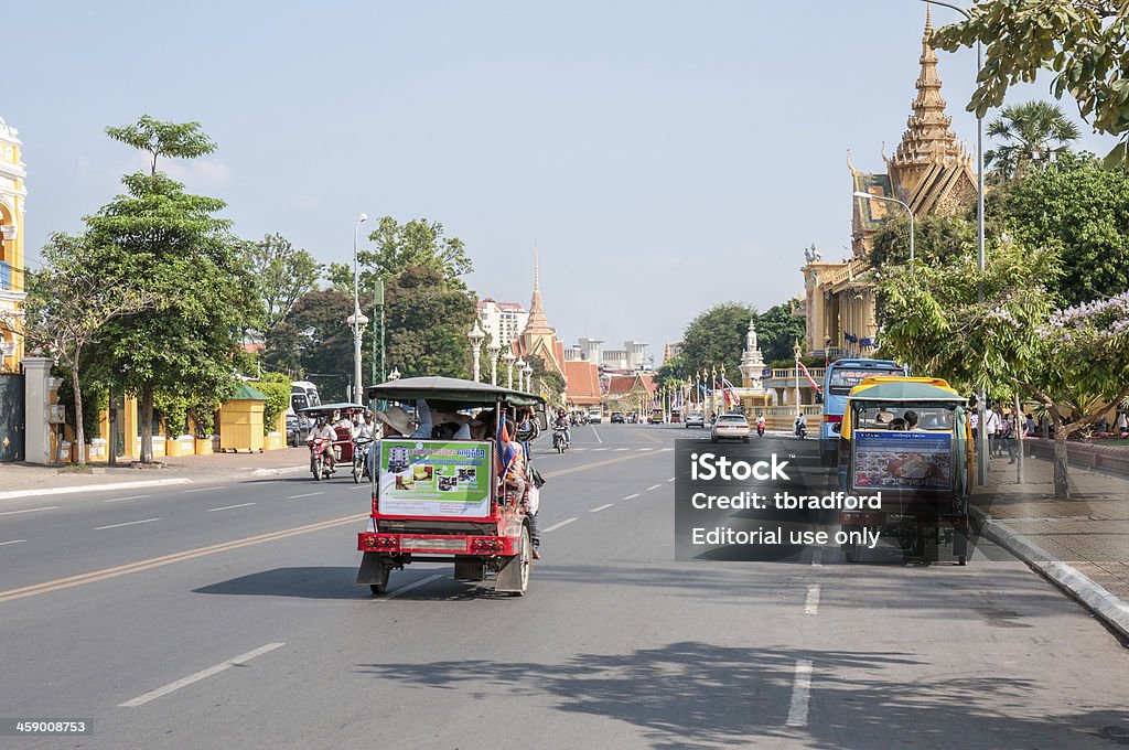 Tuktuks guida superato il Palazzo Reale di Phnom Penh - Foto stock royalty-free di Phnom Penh