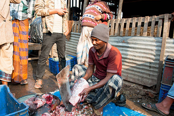 mann schneiden fisch in fishing markt, bangladesch - benglalese stock-fotos und bilder