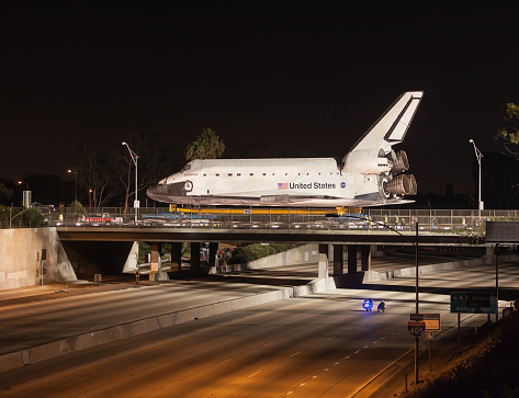Inglewood, California, USA - October 12, 2012: The Space Shuttle Endeavor crosses over an empty 405 freeway as travels through the streets of Los Angeles on it's way to it's new home at the LA Science Center. Toyota as part of a publicity campaign used a Toyota pickup truck to pull the shuttle across the bridge.