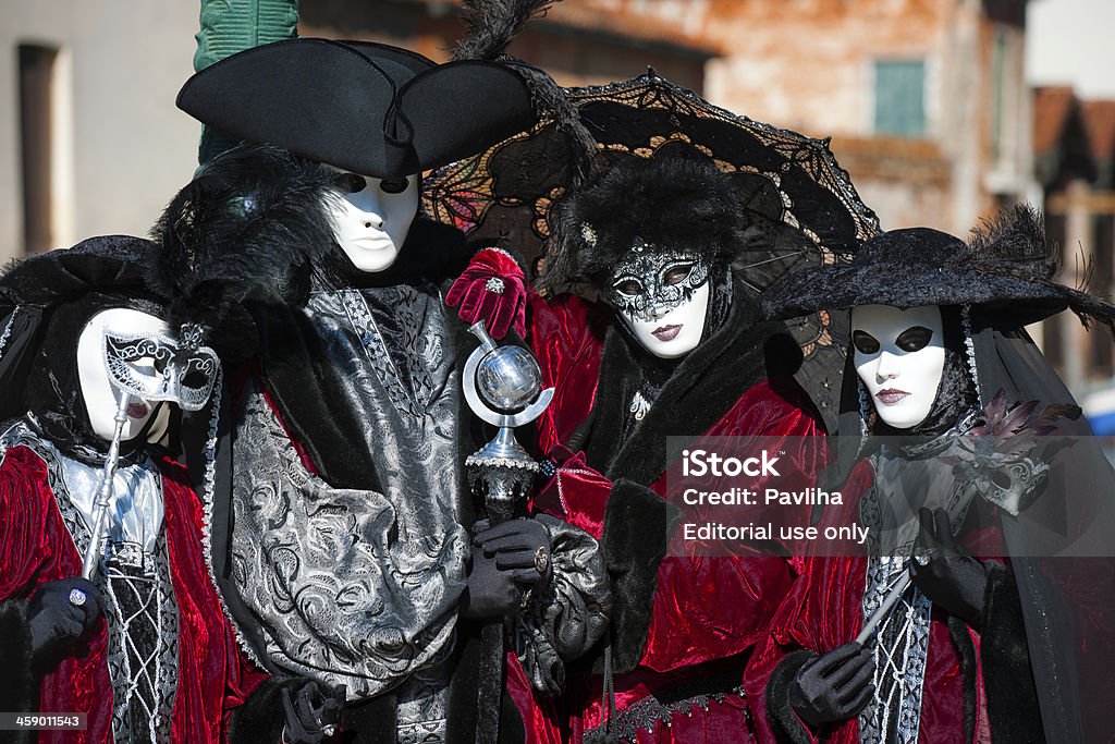 Four Masks Posing 2013 Carnival Venice Italy "Venice, Italy - February 8th, 2013: Four red and black masks posing for photographers by the church Santo Giovanni e Paolo during 2013 Carnival celebrations." Adult Stock Photo