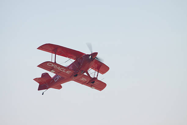 Oracle Bi-Plane "San Diego, United States- October 1, 2011: A red bi-plane advertising Oracle in mid air at the MCAS Miramar airshow." miramar air show stock pictures, royalty-free photos & images