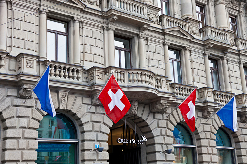 Zurich, Switzerland - April 16, 2012: On Sechselȁuten Monday the entrance to Credit Suisse at Paradeplatz in Zurich is decorated with the flags of Switzerland and the canton of Zurich.
