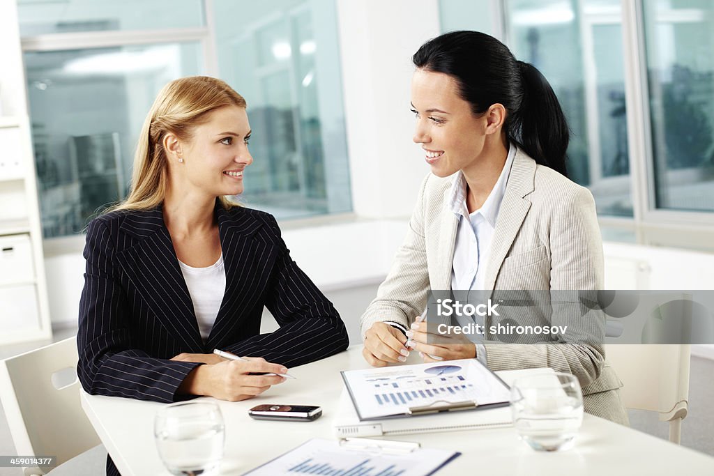 Females working Portrait of two young businesswomen planning work and looking at each other Adult Stock Photo