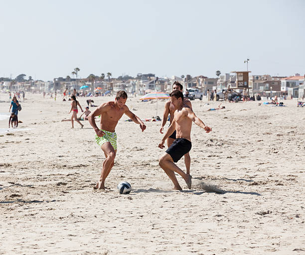 jugar al fútbol en la playa de santa mónica - american football football focus on foreground team sport fotografías e imágenes de stock