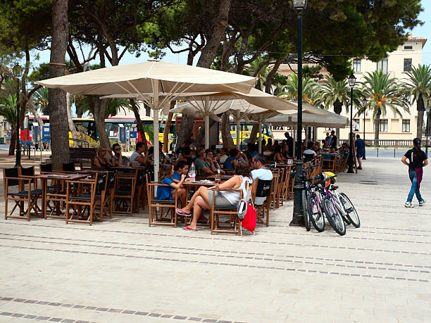 Arequipa, Peru - May 25, 2013: Restaurant menu on blackboard outside street cafes. Men and woman are pictured at the restaurant tables in sunlit cobblestoned street of Arequipa