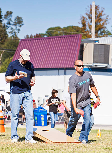 男性が cornhole - cornhole leisure games outdoors color image ストックフォトと画像