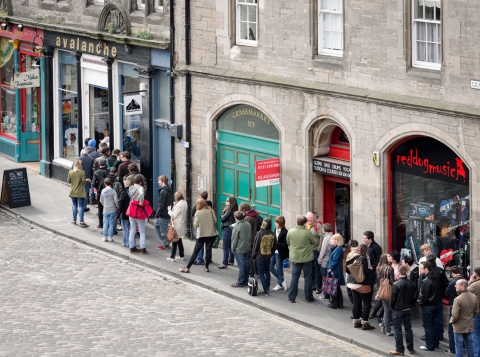 Edinburgh, UK - April 16, 2011: A long queue of people on the pavement outside Avalanche Records on Record Store Day.  Held annually since 2008, Record Store Day is celebrated around the world in independant record shops.  Avalanche Records has been trading for more than 20 years, and is one of Scotlands largest independant music shops.