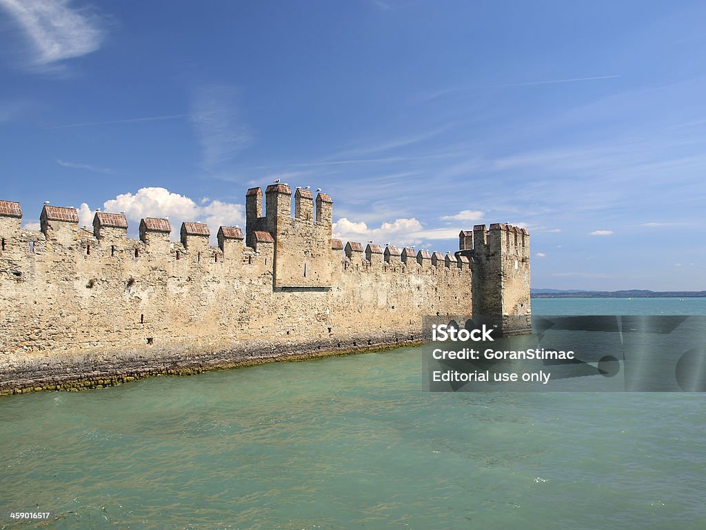 Sirmione fortification "Sirmione, Italy - August 10th 2012:Scaliger Castle (Castello Scaligero) is an ancient fortification-port guarding the entrance to the historic center of Sirmione, on Lake Garda, Italy." Ancient Stock Photo
