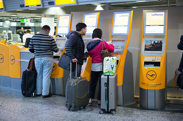 viajantes usar o lufthansa máquinas de check-in de autoatendimento no aeroporto de frankfurt - self service check in passenger people frankfurt - fotografias e filmes do acervo