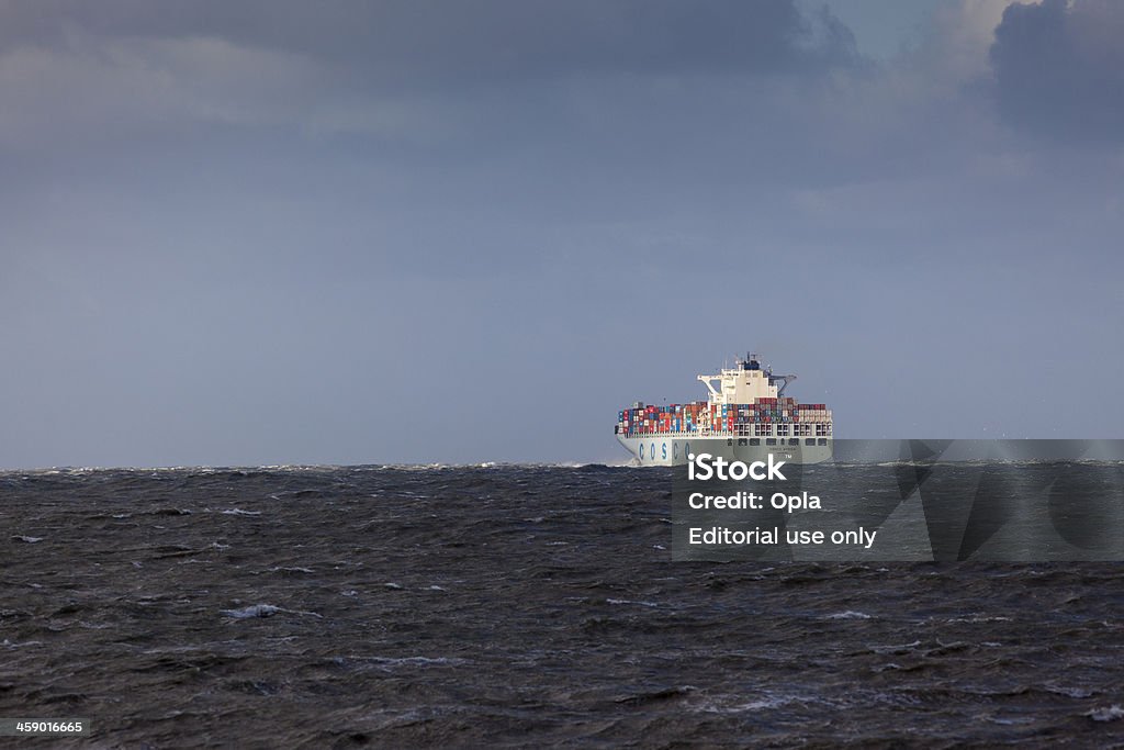 Container ship Cosco Africa leaving Rotterdam in rough weather "Rotterdam, The Netherlands - December 9, 2011: Container ship Cosco Africa leaving Rotterdam in rough weather. The Cosco group is one of the top 5 global liners with 150 ships totaling over 600 000 TEU." Sea Stock Photo