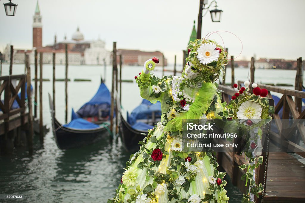 Mask at Venice Carnival 2013 in St. Mark's basin "Venice, Italy - February 3, 2013: : Woman wearing a wonderful mask participant of the 2013 carnival celebrations posing for casual photographers and tourists in St. Mark's basin" Traveling Carnival Stock Photo